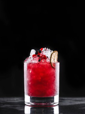 Siyah arka planda cam portakal ve çilek ile taze kırmızı kokteyl. Yaz içkileri ve alkollü kokteyller.