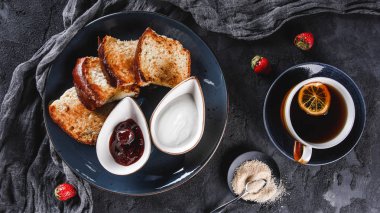 Koyu arka plan üzerinde tabaktabaktabak tatlı ev yapımı çörekler ile Kahvaltı