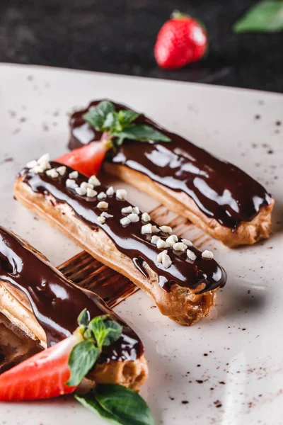 Hemlagad kaka eclairs eller Profiteroles med vaniljsås, choklad en — Stockfoto