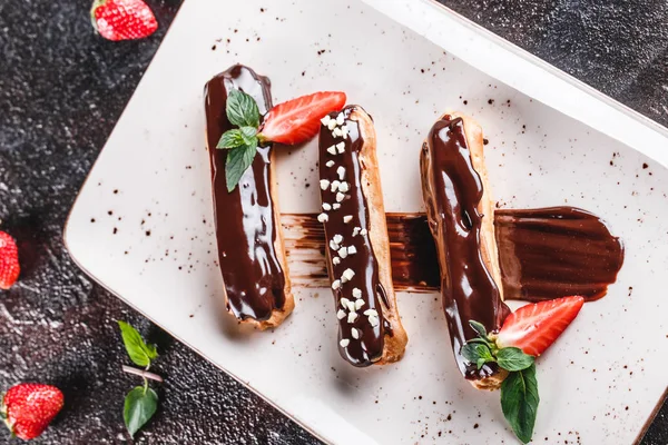 Hemlagad kaka eclairs eller Profiteroles med vaniljsås, choklad en — Stockfoto