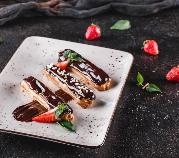 Hemlagad kaka eclairs eller Profiteroles med vaniljsås, choklad en — Stockfoto