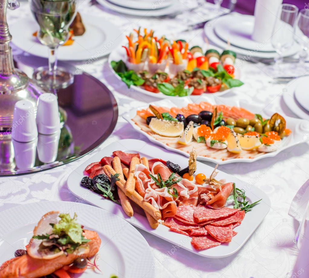 Wedding table served with tasty meals, antipasto platter cold me