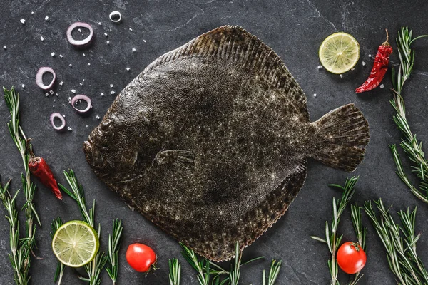 Roher ganzer Flunderfisch mit Rosmarin, Zwiebeln und Gewürzen auf dunklem — Stockfoto