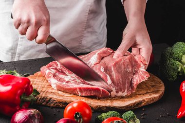 Şef Kasap mutfakta bıçak ile domuz eti kesme, pişirme fo