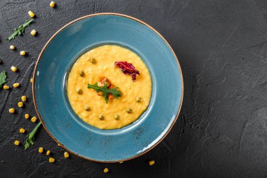 Koyu sto tabakta yeşillik ve kruton ile mısır çorbası Krem