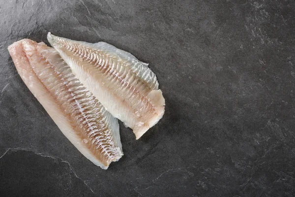 Frisches rohes Filet weißer Fisch Pangasius auf Schieferstein Hintergrund. — Stockfoto