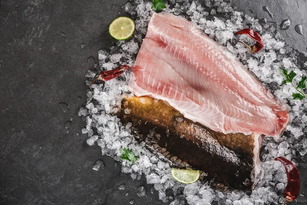 Färsk rå filé fisk och hel fisk med kryddor på is över Dar — Stockfoto