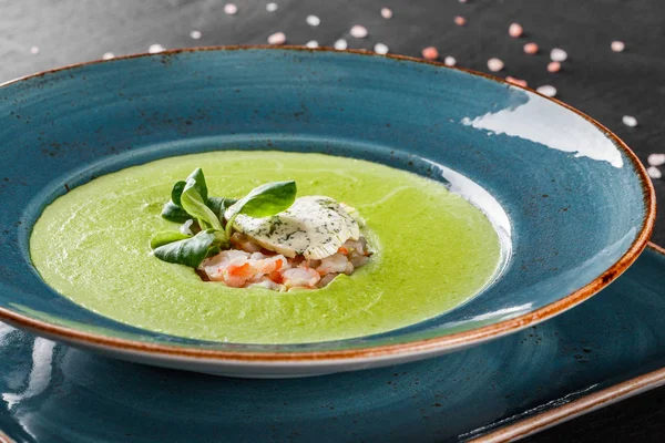 Broccoli green cream soup with shrimp and cheese in plate on dar — Stock Image Broccoli green cream soup with shrimp and cheese in plate on dar Stock Picture