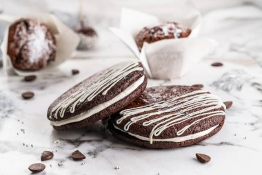 Açık mermer arka plan üzerinde krem ile Çikolatalı kurabiye. Lezzetli tatlı, yakın çekim