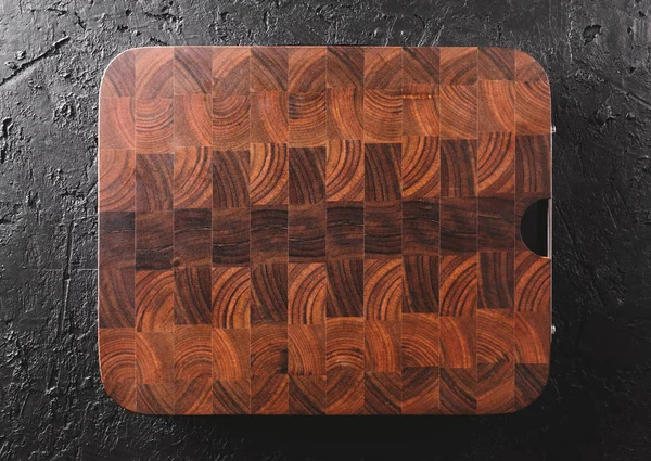 Corte de tabla de cortar sobre fondo de piedra oscura. Textura de madera . — Foto de Stock