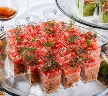 Ziyafet masasında cam bardaklarda et, sebze, yeşillik li lezzetli mezeler. Catering gıda, kanepe ve aperatifler