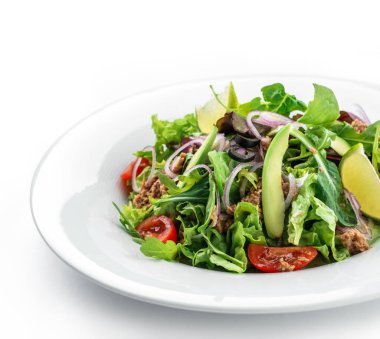 Arugula, marul, domates, avokado, limon, ton balığı ve izole beyaz arka plan üzerinde tabakta zeytin ile yeşil salata. Sağlıklı yemek, temiz beslenme, diyet