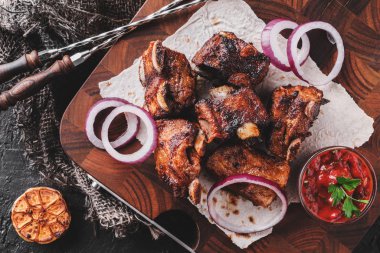Izgara et ya da şiş kebap, ahşap tahtada domates soslu shashlik koyu taş arka planda. Üst görünüm