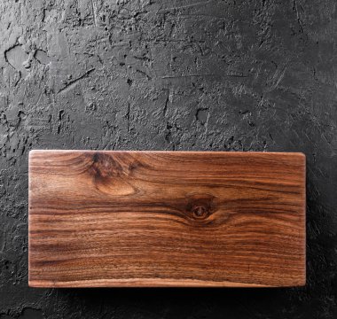 Koyu taş arka plan üzerinde kesme tahtası doğrama. Ahşap doku.