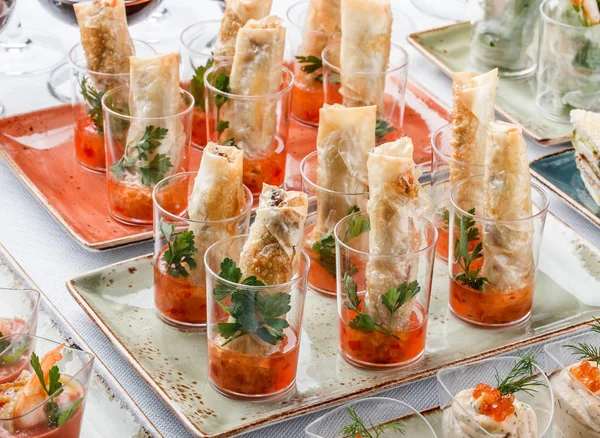 Läckra förrätter i glaskoppar på bankettbord. Catering mat, kanapé och snacks — Stockfoto