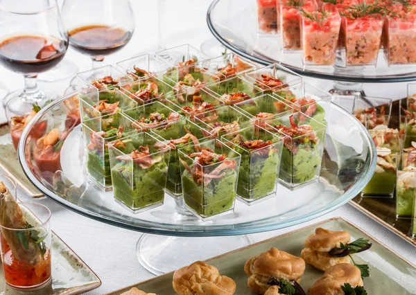 Läckra aptitretare med grön mousse, ost, kött i glas koppar på bankett bord. Matservering, Canape Connection och tilltugg — Stockfoto