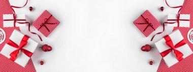 Kırmızı kurdeleli Noel hediyesi kutuları ve beyaz ve kırmızı arka planda süslemeler. Xmas ve Mutlu Yıllar teması, kar. Düz konum, üst görünüm, geniş kompozisyon