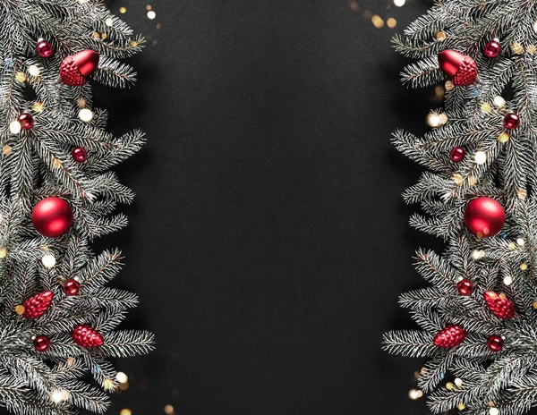 Δημιουργικό πλαίσιο διάταξης από κλαδιά χριστουγεννιάτικου δέντρου, κουκουνάρια, κόκκινη διακόσμηση σε σκούρο φόντο. Χριστούγεννα και Πρωτοχρονιάτικες διακοπές. Επίπεδο lay, πάνω όψη — Φωτογραφία Αρχείου