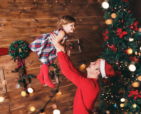 God Jul och Gott Nytt År! Far och dotter ler i vardagsrummet dekorerade med julgran och julklappslådor. Porträtt kärleksfull familj på nära håll, semester — Stockfoto