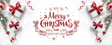 Hediye kutuları, kurdeleler, kırmızı süslemeler, köknar dalları, bokeh, pırıltı ve konfeti içeren beyaz arkaplan üzerine Mutlu Noeller metni. Xmas ve yeni yıl tebrik kartı, bokeh, ışık. Düz yatış, üst görünüm