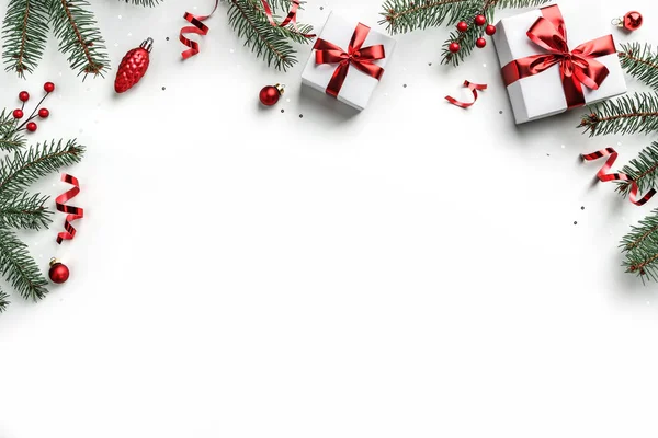Branches de sapin de Noël, boîtes-cadeaux avec ruban rouge, décoration rouge, étincelles et confettis sur fond blanc. Carte de voeux de Noël et Nouvel An, vacances d'hiver. Couché plat, vue du dessus — Photo