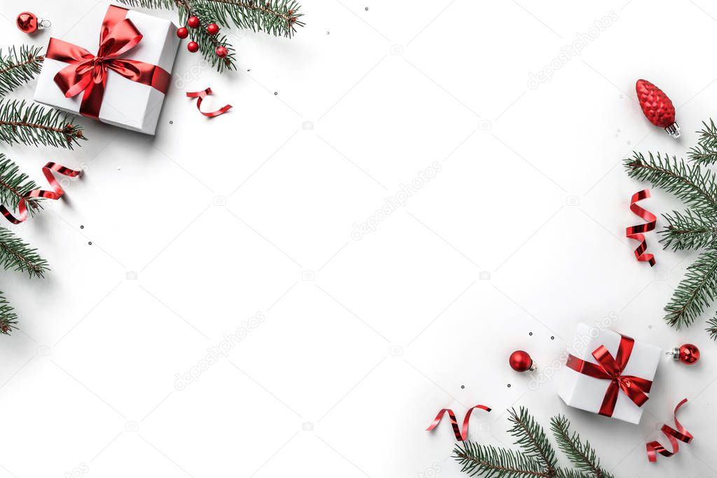 Christmas fir branches, gift boxes with red ribbon, red decoration, sparkles and confetti on white background. Xmas and New Year greeting card, winter holiday. Flat lay, top view