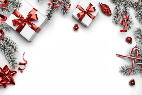 Творческая рамка из еловых ветвей, подарочных коробок, красного декора, блесток и конфетти на белом фоне. Рождество и Новый год, боке, свет. Плоский, вид сверху — стоковое фото