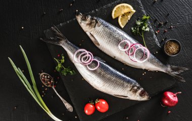 Baharat, yeşillik ve soğan arkaplanda salamura edilmiş uskumru ya da ringa balığı. Akdeniz yemekleri, aperatifler, deniz ürünleri, üst manzara.
