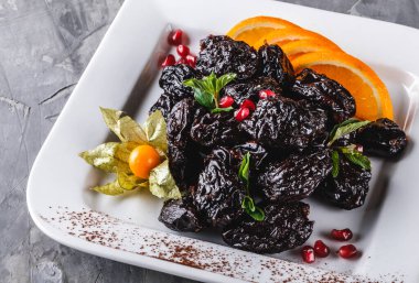 Fındıklı kurutulmuş erikli tatlı ve gri arka planda portakal. Sağlıklı yemek, diyet.