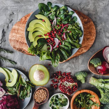 Avokado, yeşillik, roka, ıspanak ve nar içeren sağlıklı taze salata. Sağlıklı vejetaryen yemekleri, temiz yemek, perhiz, üst manzara.
