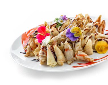 Doldurulmuş krep ya da krep, üzerine peynir, reçel ve çikolata dökülmüş beyaz arka planda izole edilmiş tabakta. Aperatif tabağı. Sağlıklı kahvaltı, kapat.