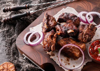 Izgara et ya da şiş kebap, ahşap tahtada domates soslu shashlik koyu taş arka planda. Üst görünüm