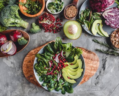 Avokado, yeşillik, roka, ıspanak ve nar içeren sağlıklı taze salata. Sağlıklı vejetaryen yemekleri, temiz yemek, perhiz, üst manzara.