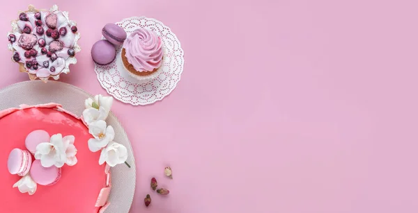 マカロンで装飾された鏡釉のピンクムースケーキ ピンクの休日の背景に幸せな誕生日のための花 お祝いのケーキよ トップビュー フラットレイアウト — ストック写真