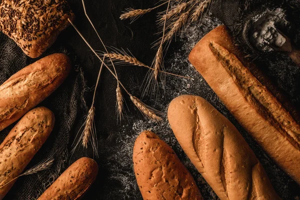 Variety Delicious Breads Buns Dark Slate Background Wheat Spikiletes Sackcloth — Stock Photo, Image