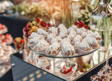 Düğün tatlısı, kurabiyeler, pastalar, kekler, kekler, pastalar ve çiçeklerle dolu tatil arkaplanda tatlılık. Şeker çubuğu