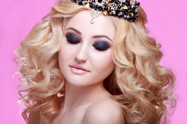Beautiful blonde woman with long Curly hair wearing crown decorated gemstones. Professional make up for blonde. Hairdressing, hairstyle. Sexy Model. Perfect Skin and Make up