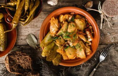 Ev yapımı kızarmış patates, domuz pastırması, dereotu ve turşu, ahşap arka plan, üst manzara.