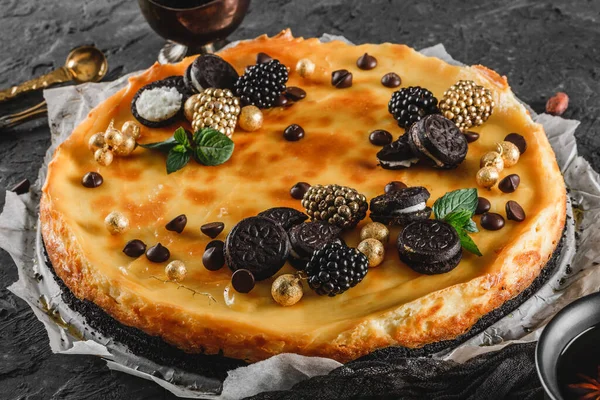 キャラメル ミニオレオ ミントの葉 ダークな背景の上に紙の上のベリーと古典的なチーズケーキは ビューを閉じます おいしいお菓子とデザート — ストック写真