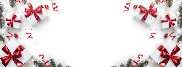 白い背景にクリスマスモミの枝 ギフトボックス 赤の装飾 輝きとコンフェッティで作られた創造的なフレーム クリスマスと新年の休日 フラットレイアウト トップビュー — ストック写真