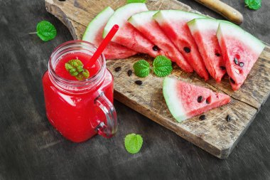 Karpuz suyu ve koyu ahşap arka plan, rustik tarzı üzerinde karpuz parçaları