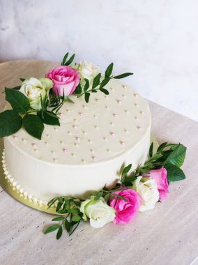 Mermer masa ve beyaz arka plan üzerinde çiçekli güzel düğün pastası