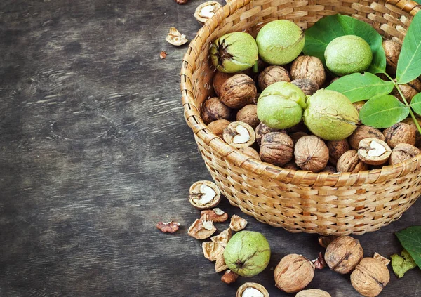 Whole Walnuts and Cleared in the basket Black Wooden Background Top view Healthy concept — Stock Photo, Image