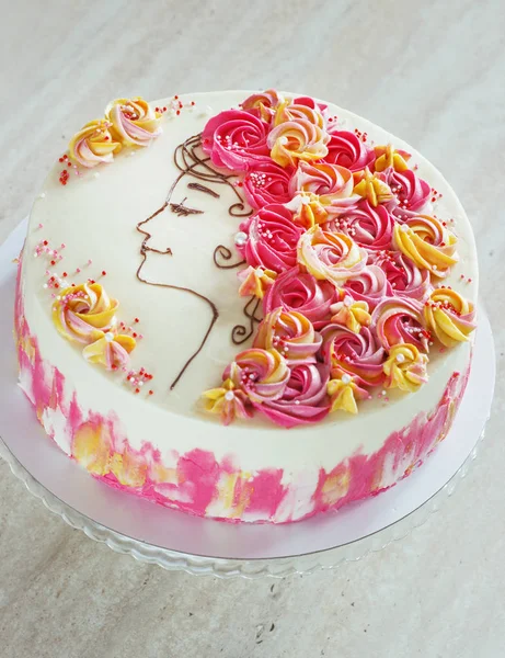 Świąteczne ciasto, z kremowymi kwiatkami i dziewczyna twarz na jasnym tle — Zdjęcie stockowe