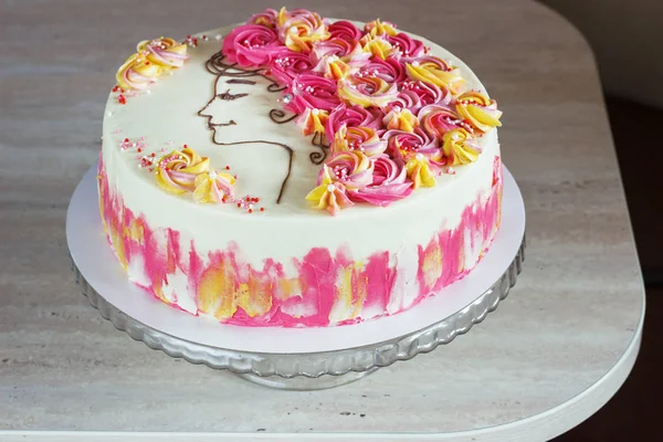 Pastel festivo con flores de crema y una cara de niña sobre un fondo claro —  Fotos de Stock