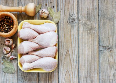 Ahşap arka plan, üstten görünüm üzerinde çiğ tavuk budu ile kase