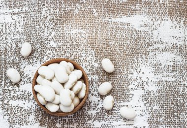 Ahşap kase, aynı zamanda kuru, inci kuru, boston, beyaz veya bezelye fasulye fasulye deniz kuvvetleri. Phaseolus vulgaris, bir baklagil kurutulmuş tohumları. Gıda fotoğraf yakın çekim yukarıdan beyaz arka plan üzerinde