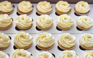 Bir gül şeklinde bir şapka ile karton kutu içinde Lezzetli cupcakes