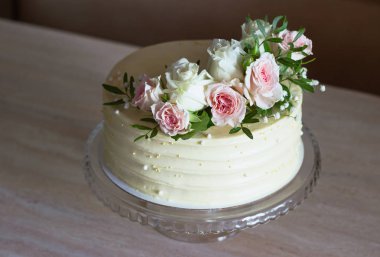 Mermer masa ve beyaz arka plan üzerinde çiçekli güzel düğün pastası