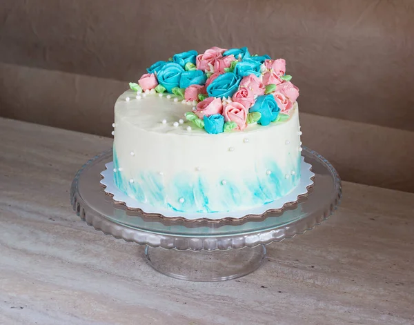 Hermoso pastel cubierto de rosas brillantes hechas de crema de mantequilla glaseado sobre fondo de madera clara — Foto de Stock